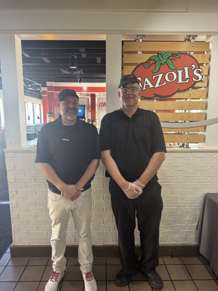 Adam Aide standing in front of Fazoli's Sign.